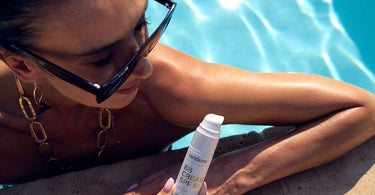 Kobieta w basenie ma ubrane okulary i ogląda kosmetyk.