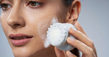 Aby usunąć pryszcze podskórne kobieta m.in. myje twarz przy pomocy szczoteczki