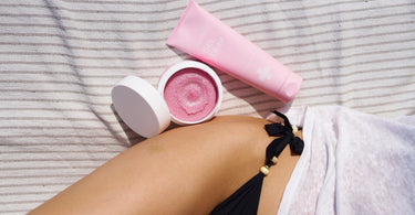 Kobieta leży na ręczniku, a obok niej położone są kosmetyki, które pomagają pielęgnować truskawkowe nogi po goleniu.