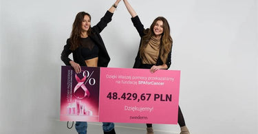 Kobiety trzymają w rękach czek, który chcą podarować fundacji Spa for Cancer w ramach akcji różowy październik