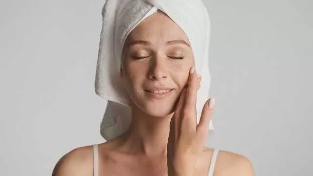 Na zdjęciu kobieta dotyka skóry na twarzy. Kluczowym białkiem strukturalnym organizmu jest kolagen naturalny. Gdzie występuje? Można go znaleźć w skórze, kościach, ścięgnach, chrząstkach, naczyniach krwionośnych i narządach wewnętrznych.